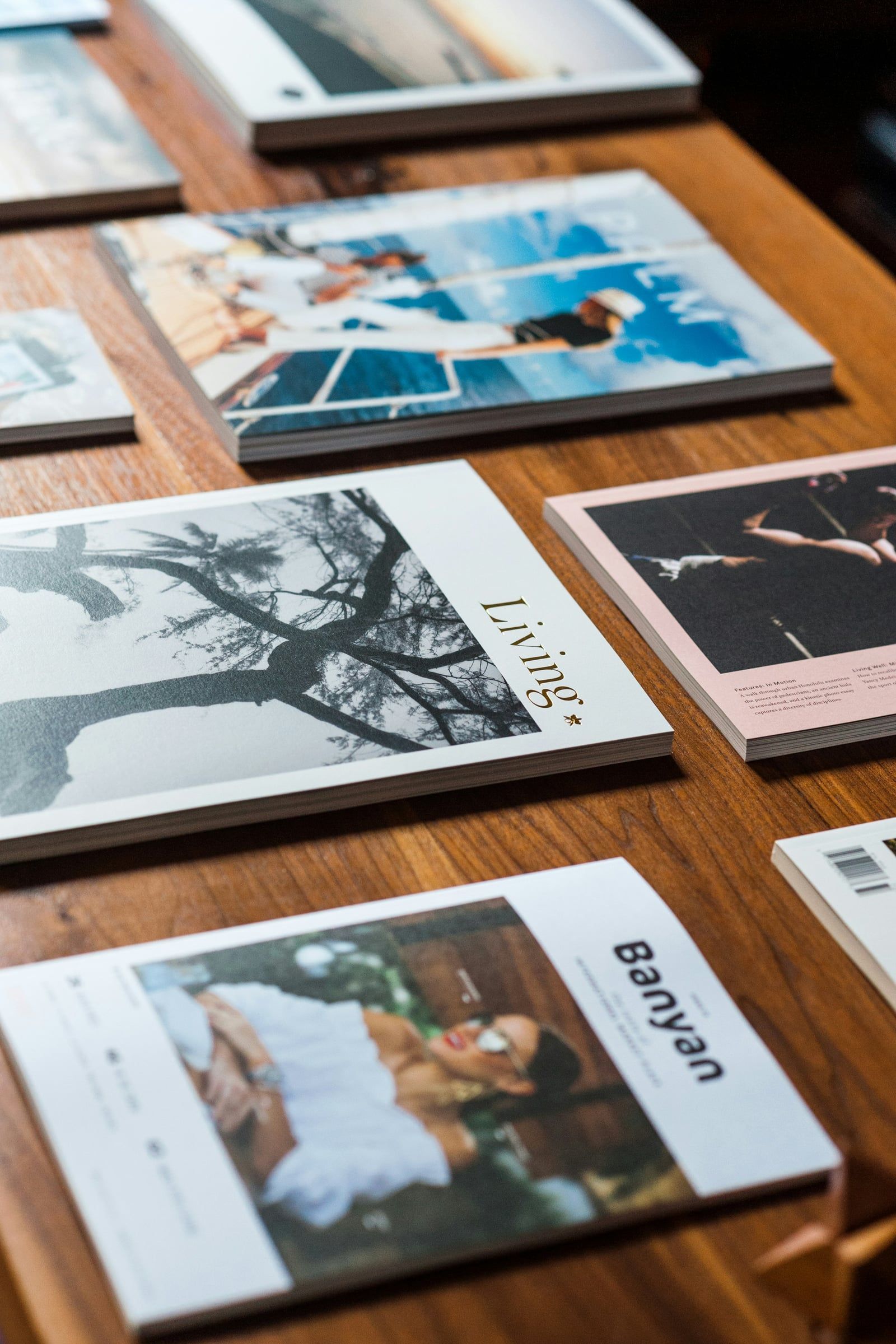 Printed magazines and brochures spread across a wooden table