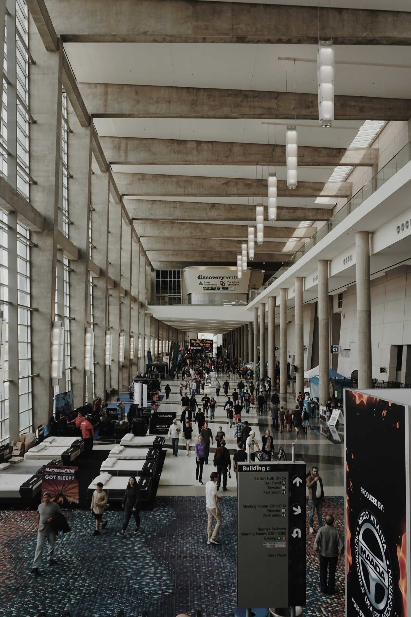 Busy exhibition hall with visitors walking between stands