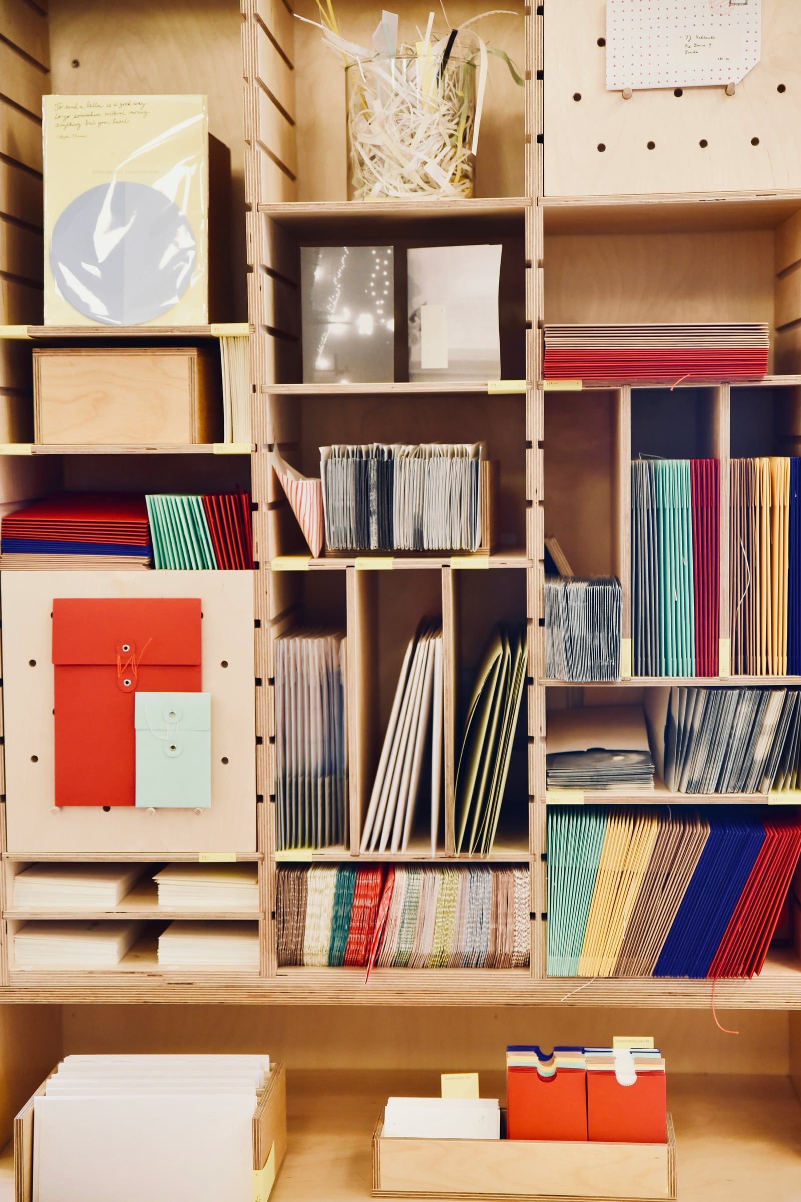 Wooden shelves stacked with paper, folders and stationery